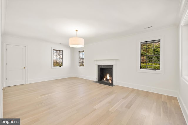 unfurnished living room with a fireplace, ornamental molding, and light hardwood / wood-style flooring