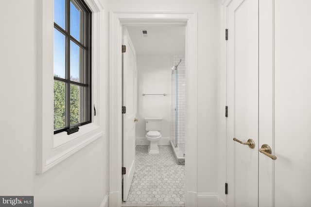 bathroom with baseboards, walk in shower, toilet, and tile patterned floors