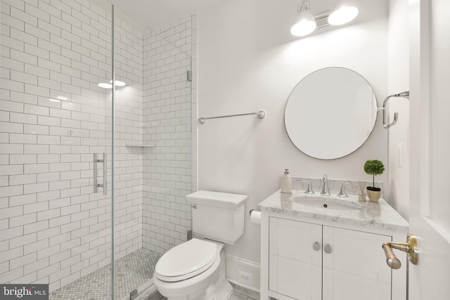 full bathroom featuring a stall shower, vanity, and toilet