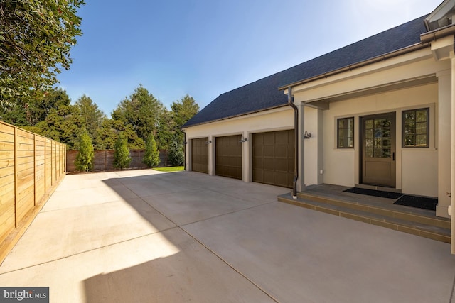 view of property exterior with a garage and a patio area