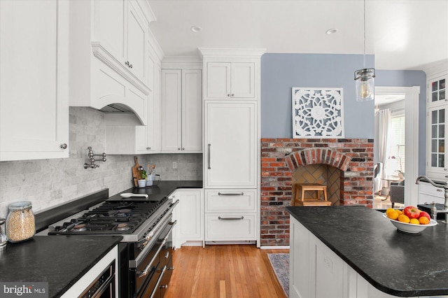 kitchen with white cabinets, pendant lighting, light hardwood / wood-style floors, and high end range