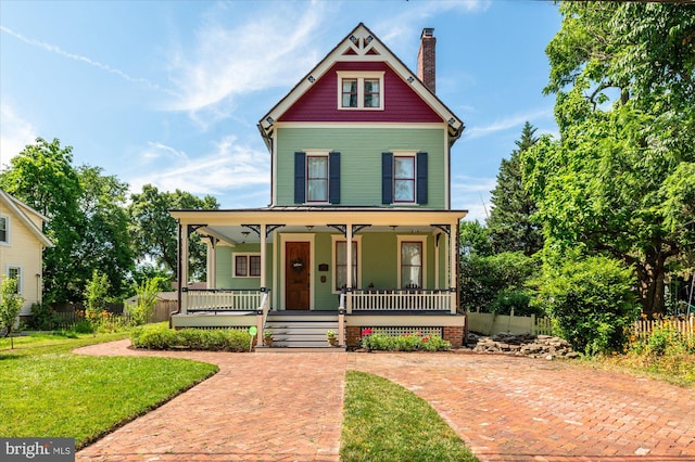 victorian home featuring a porch and a front lawn