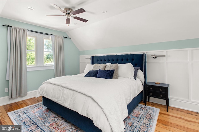 bedroom featuring light hardwood / wood-style floors, vaulted ceiling, and ceiling fan