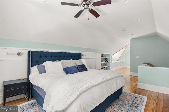 bedroom with light hardwood / wood-style floors, vaulted ceiling, and ceiling fan