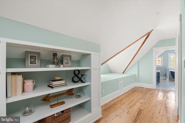 interior space with light hardwood / wood-style flooring and vaulted ceiling