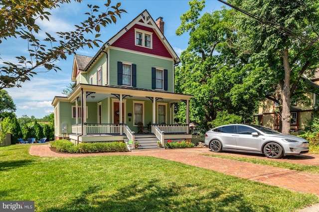 victorian home with a porch and a front yard