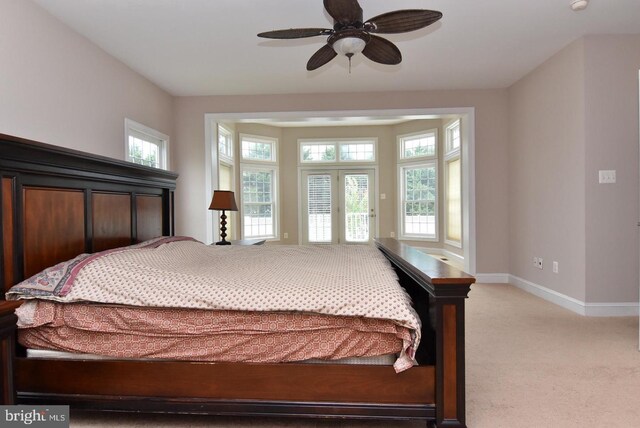 carpeted bedroom with multiple windows and ceiling fan