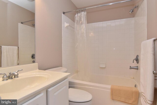 full bathroom featuring vanity, shower / tub combo, and toilet