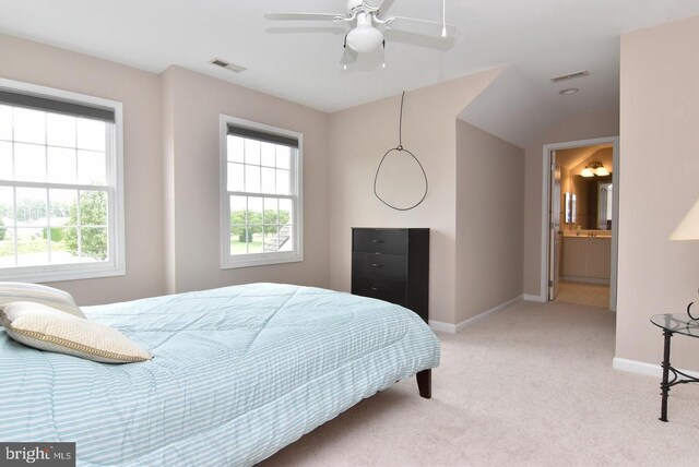 bedroom with carpet floors, ceiling fan, and connected bathroom