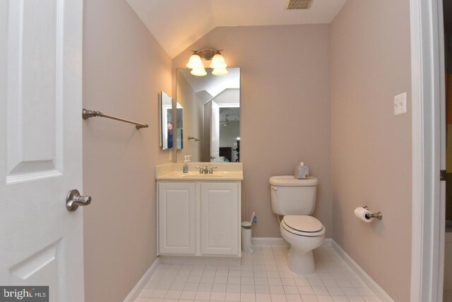 bathroom featuring vanity, toilet, lofted ceiling, and tile patterned flooring