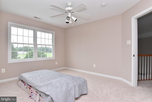 bedroom with light carpet and ceiling fan