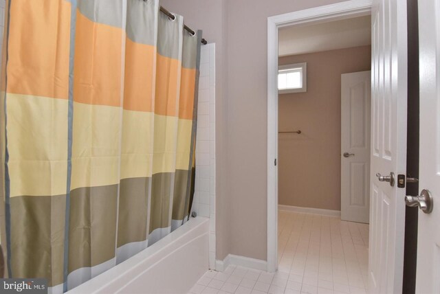 bathroom with shower / bath combo with shower curtain and tile patterned flooring