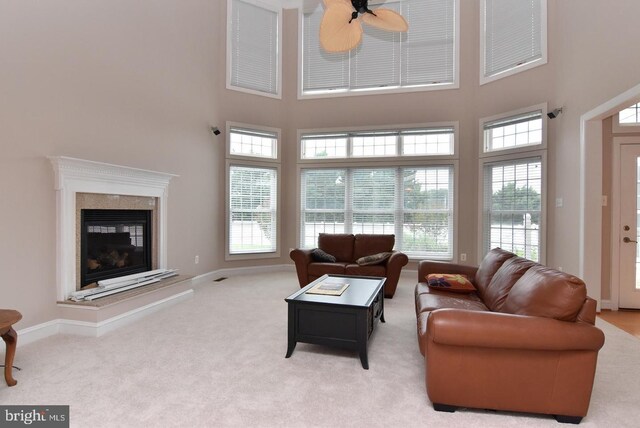 living room featuring light carpet, a fireplace, ceiling fan, and plenty of natural light