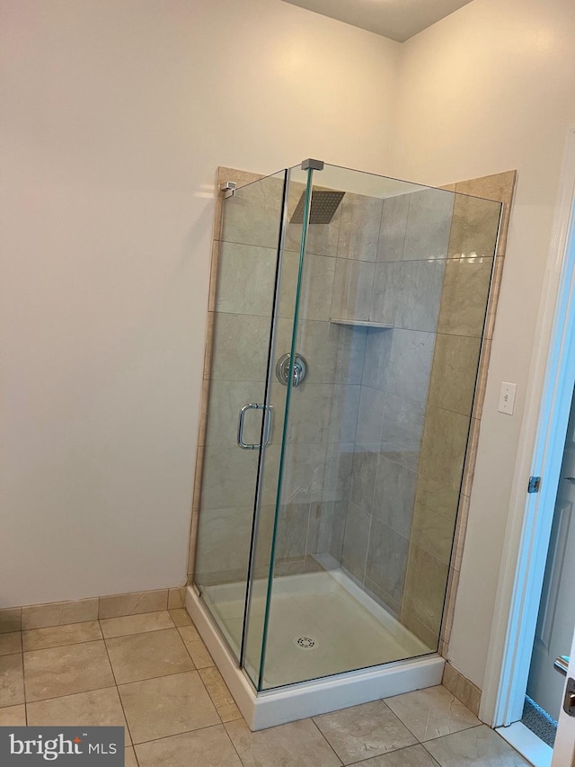 bathroom featuring a shower with shower door and tile patterned flooring