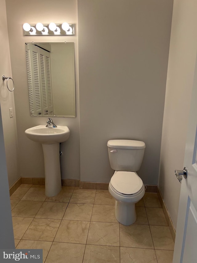 bathroom featuring toilet and tile patterned flooring