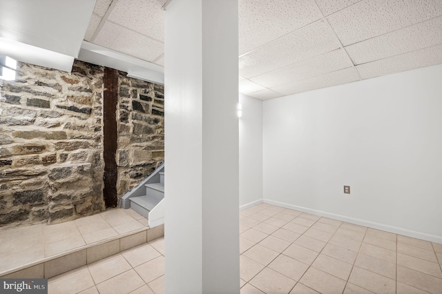 basement featuring a drop ceiling and tile patterned flooring