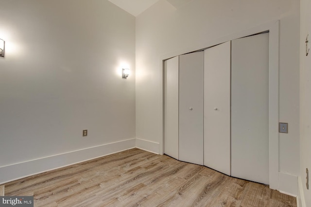 unfurnished bedroom with light hardwood / wood-style floors and a closet