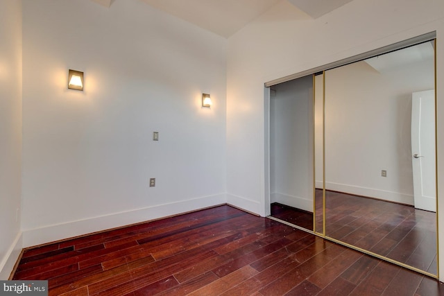 unfurnished bedroom featuring a closet and dark hardwood / wood-style floors