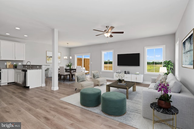 living room featuring ceiling fan, sink, and light hardwood / wood-style floors