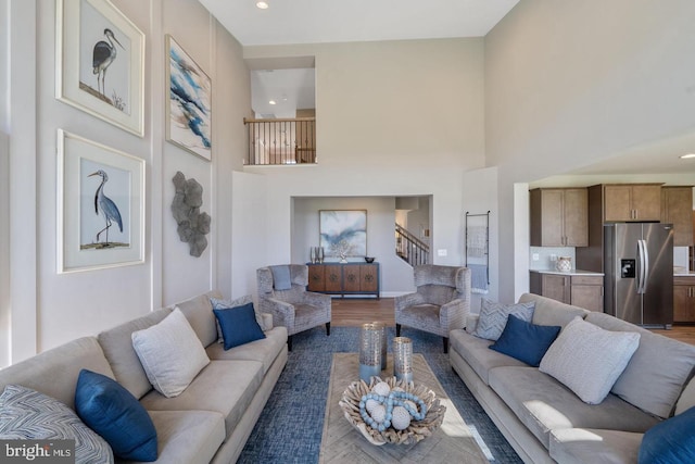 living room featuring dark hardwood / wood-style flooring and a towering ceiling