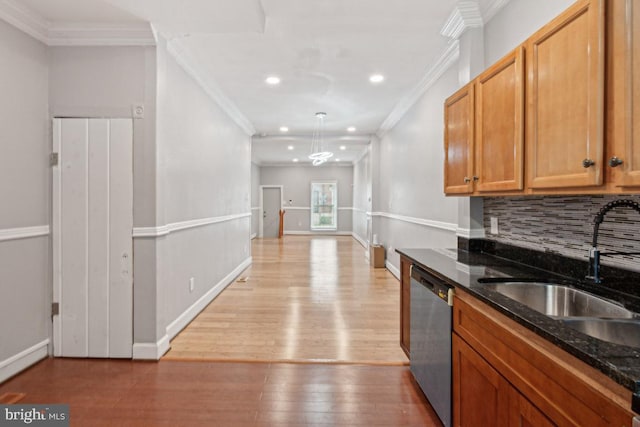 kitchen featuring sink, decorative light fixtures, dark stone countertops, stainless steel dishwasher, and backsplash