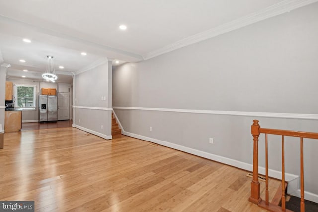 unfurnished living room featuring crown molding and light hardwood / wood-style floors