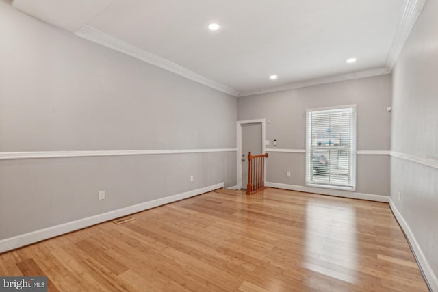 unfurnished room with ornamental molding and light wood-type flooring