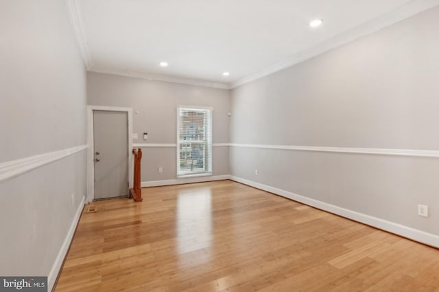 empty room with ornamental molding and light hardwood / wood-style floors