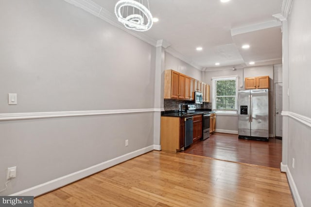 kitchen with tasteful backsplash, an inviting chandelier, ornamental molding, stainless steel appliances, and light hardwood / wood-style floors