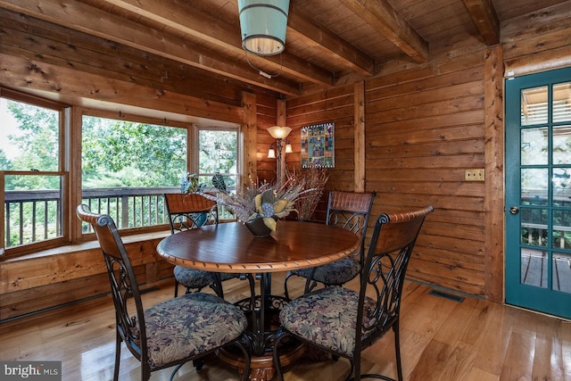 dining area featuring wooden ceiling, beam ceiling, light hardwood / wood-style floors, and a healthy amount of sunlight