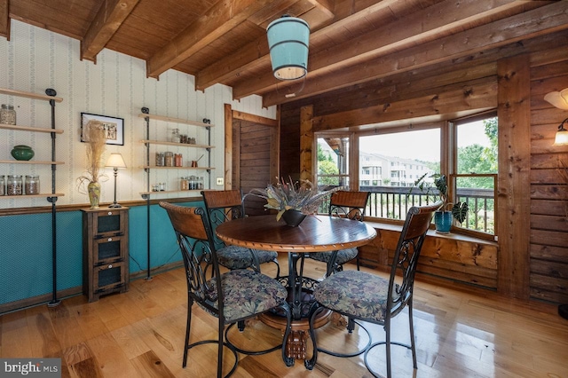 dining room featuring light wood-type flooring, plenty of natural light, beamed ceiling, and wooden ceiling