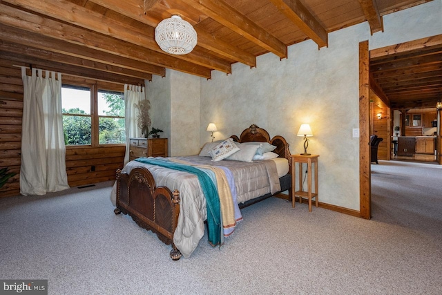 bedroom with carpet floors, beam ceiling, and wood ceiling