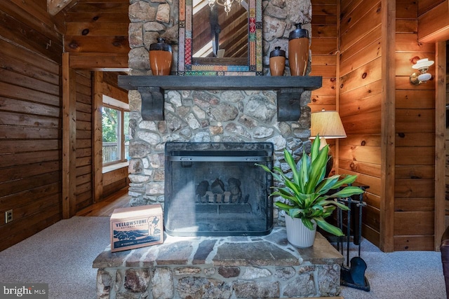 room details featuring carpet flooring, a stone fireplace, and wooden walls