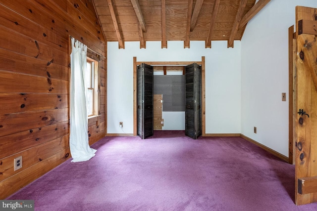 carpeted spare room with wood walls, wood ceiling, and vaulted ceiling with beams