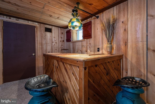 bar with wood counters, wood walls, and wooden ceiling