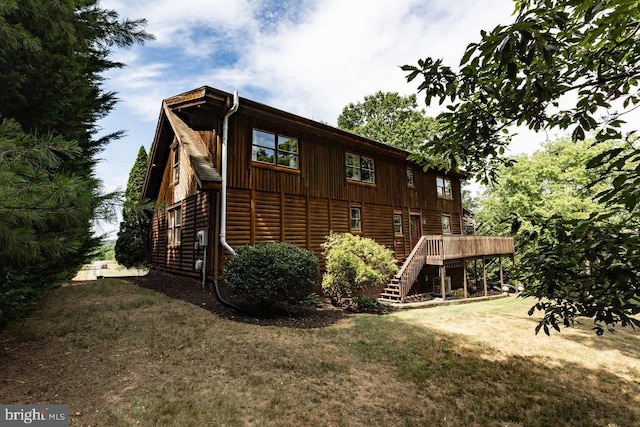 view of side of property with a lawn and a deck