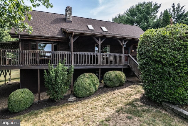 rear view of property with a lawn and a deck