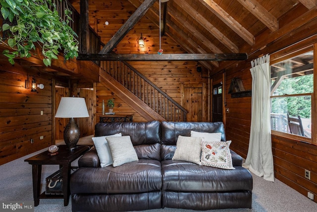 carpeted living room with beam ceiling, wood ceiling, wood walls, and high vaulted ceiling