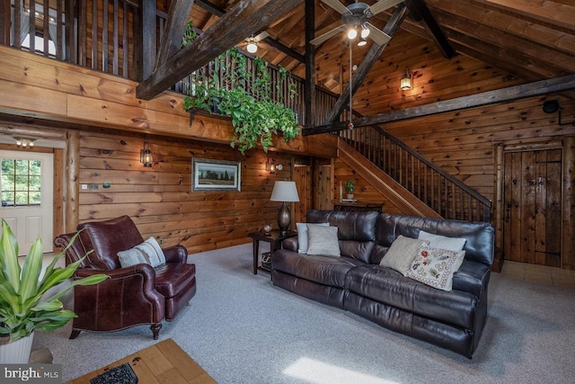 carpeted living room with wood ceiling, wooden walls, ceiling fan, high vaulted ceiling, and beam ceiling