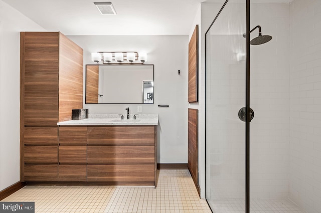 bathroom featuring tiled shower and vanity