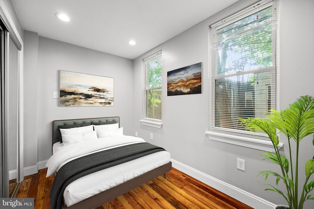 bedroom with dark hardwood / wood-style floors and a closet