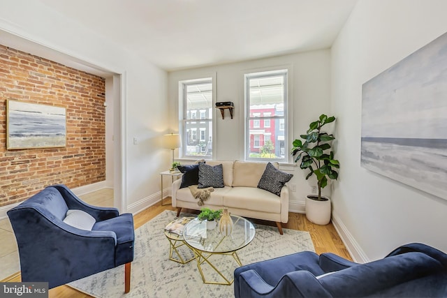 living room featuring brick wall and light hardwood / wood-style flooring