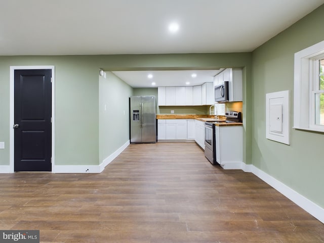 kitchen featuring white cabinetry, sink, stainless steel appliances, and light hardwood / wood-style floors