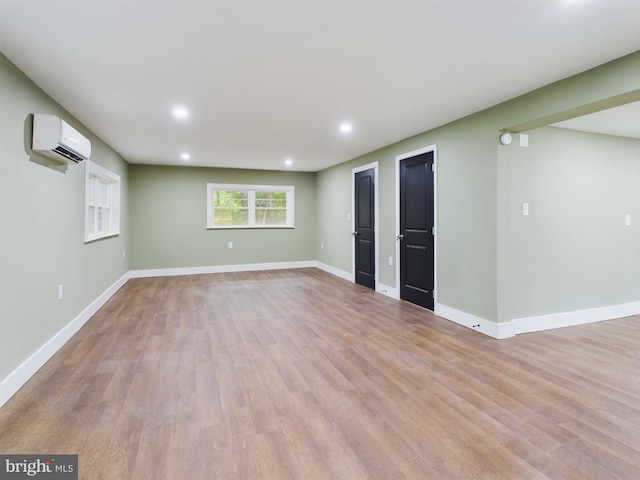 interior space with a wall unit AC and light wood-type flooring