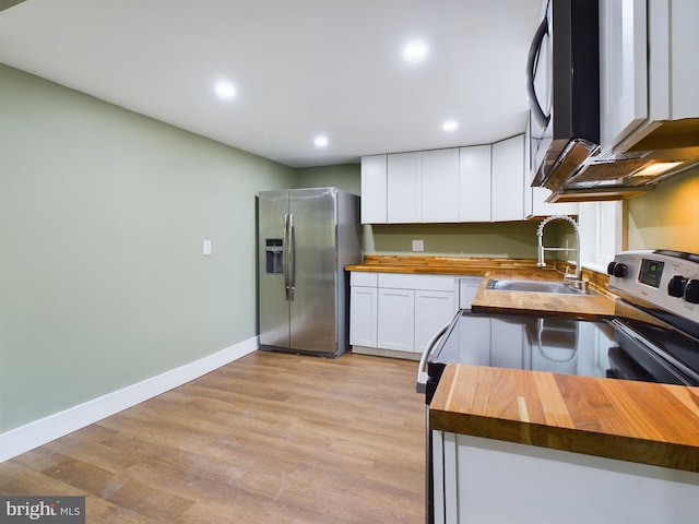 kitchen with white cabinetry, sink, wooden counters, and appliances with stainless steel finishes