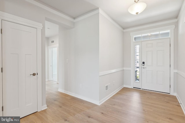 entryway featuring light wood-type flooring and ornamental molding