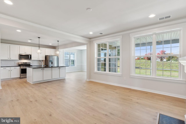 kitchen with pendant lighting, sink, light wood-type flooring, appliances with stainless steel finishes, and white cabinets