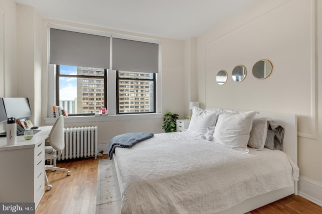 bedroom featuring wood-type flooring and radiator