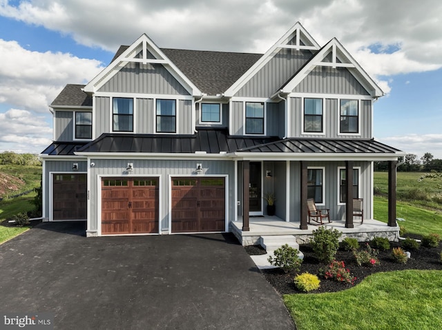 view of front facade with a garage, a front lawn, and covered porch