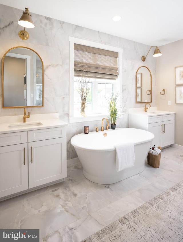 bathroom with vanity, tile walls, and a bathing tub